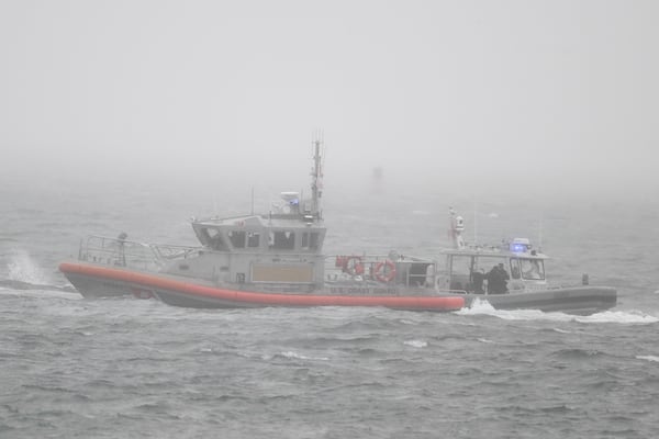 A U.S. Coast Guard boat, left, and a U.S. Navy boat work near Shelter Island after a U.S. Navy plane crashed into the San Diego Bay, Wednesday, Feb. 12, 2025, in San Diego.(AP Photo/Denis Poroy)