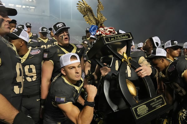 Army players hoist the winner's trophy following their win over Louisiana Tech during a NCAA college football game, Saturday, Dec. 28, 2024, in Shreveport, La. (AP Photo/Rogelio V. Solis)