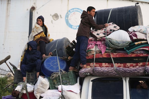 Displaced Palestinians, carrying their belongings, move away from the areas where the Israeli army is operating after Israel's renewed offensive in the Gaza Strip, on the outskirts of Beit Lahia, Thursday, March 20, 2025. (AP Photo/Jehad Alshrafi)