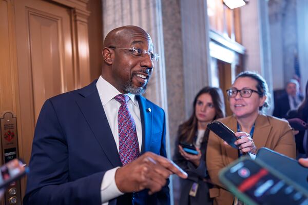 Sen. Raphael Warnock, D-Ga., responds to reporters as the Senate works to avert a partial government shutdown ahead of the midnight deadline, at the Capitol in Washington, Friday, March 14, 2025. (AP Photo/J. Scott Applewhite)