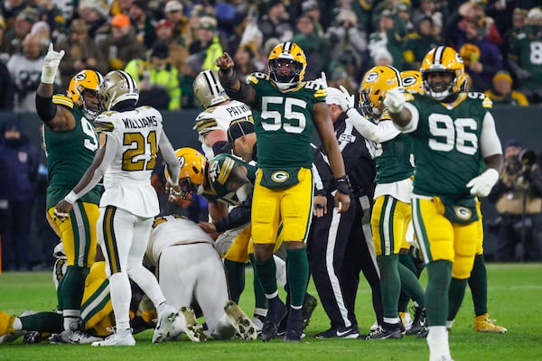 Green Bay Packers defensive end Kingsley Enagbare (55) and defensive tackle Colby Wooden (96) celebrate a fumble recovery during the first half of an NFL football game against the New Orleans Saints, Monday, Dec. 23, 2024, in Green Bay, Wis. (AP Photo/Mike Roemer)