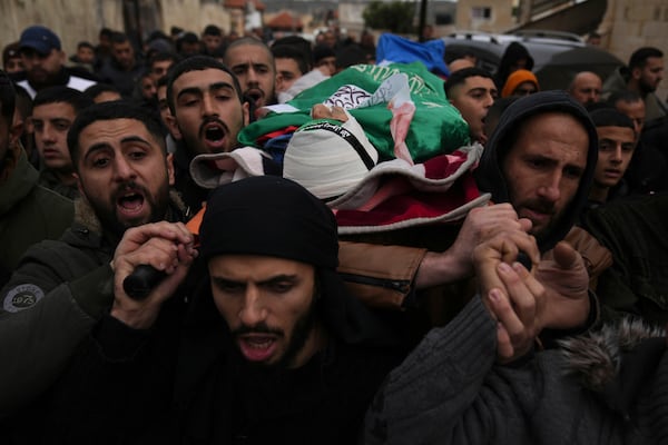 FILE - Mourners carry the body of Palestinian Zein Atatrah, 18, wrapped with a Hamas flag during his funeral in Ya'bad, West Bank, on Dec. 27, 2024. (AP Photo/Nasser Nasser, File)