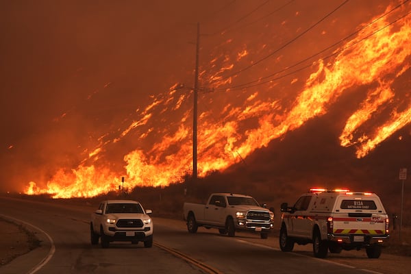 Fighter fighters monitor flames caused by the Hughes Fire along Castaic Lake in Castaic, Calif., Wednesday, Jan. 22, 2025. (AP Photo/Marcio Jose Sanchez)