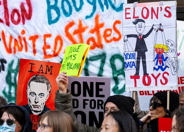 People hold up signs during a protest in support of the Consumer Financial Protection Bureau (CFPB), Monday, Feb. 10, 2025, at CFPB headquarters in Washington. (AP Photo/Jacquelyn Martin)