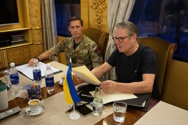 British Prime Minister Keir Starmer, right, is briefed by his unidentified military assistant on a train bound for Kyiv Thursday, Jan. 16, 2025 in Ukraine. (Carl Court/Pool Photo via AP)