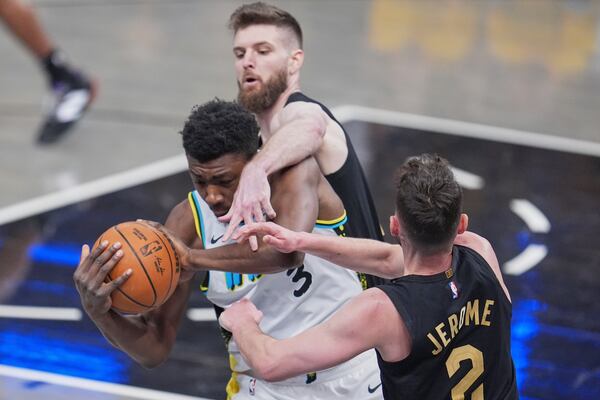 Indiana Pacers center Thomas Bryant (3) battles for the ball with Cleveland Cavaliers forward Dean Wade, top, and guard Ty Jerome (2) during the first half of Game 3 in the Eastern Conference semifinals of the NBA basketball playoffs in Indianapolis, Friday, May 9, 2025. (AP Photo/Michael Conroy)
