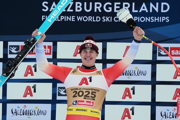 Switzerland's Franjo von Allmen celebrates winning a gold medal in a men's downhill race, at the Alpine Ski World Championships, in Saalbach-Hinterglemm, Austria, Sunday, Feb. 9, 2025. (AP Photo/Giovanni Auletta)