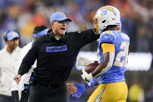 Los Angeles Chargers running back Hassan Haskins, left, celebrates his rushing touchdown with head coach Jim Harbaugh during the second half of an NFL football game against the Denver Broncos, Thursday, Dec. 19, 2024, in Inglewood, Calif. (AP Photo/Ryan Sun)