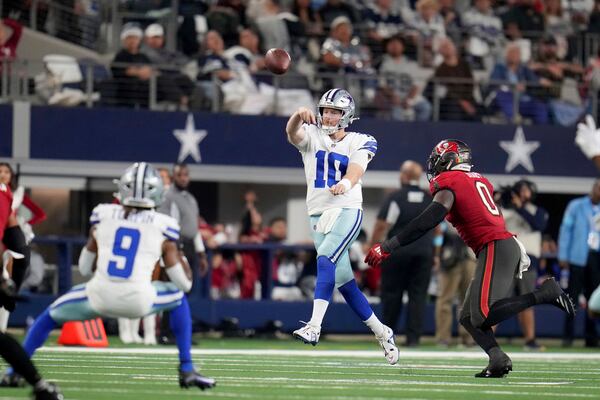 Dallas Cowboys quarterback Cooper Rush (10) throws a pass under pressure from Tampa Bay Buccaneers linebacker Yaya Diaby (0) in the second half of an NFL football game in Arlington, Texas, Sunday, Dec. 22, 2024. (AP Photo/Julio Cortez)