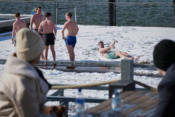 People enjoy a sunny and frosty day after sweating in the sauna of the public bath in Helsinki, Finland, Saturday, March 15, 2025. (AP Photo/Sergei Grits)