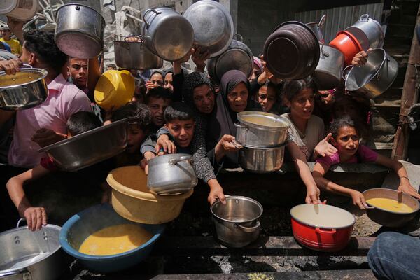 Palestinians struggle to get donated food at a community kitchen in Jabalia, northern Gaza Strip, Monday, May 19, 2025. (AP Photo/Jehad Alshrafi)