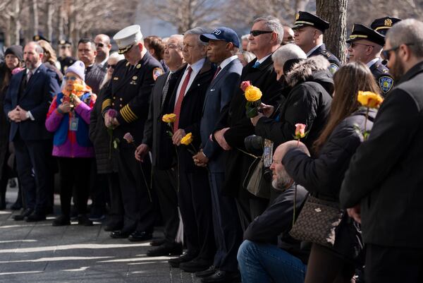 New York Mayor Eric Adams holds a flower and listens to speakers during a ceremony marking the anniversary of the 1993 World Trade Center bombing at the 9/11 Memorial, Wednesday, Feb. 26, 2025, in New York. (AP Photo/John Minchillo)