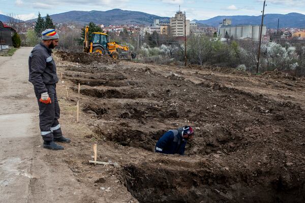 Workers dig graves for the victims of a massive nightclub fire in the town of Kocani, North Macedonia, Tuesday, March 18, 2025. (AP Photo/Visar Kryeziu)