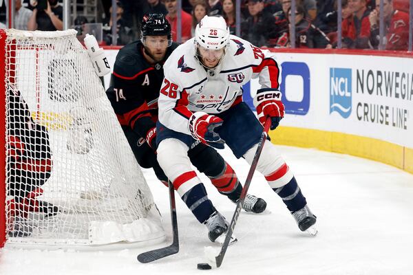 Washington Capitals' Nic Dowd (26) controls the puck in front of Carolina Hurricanes' Jaccob Slavin (74) during the first period of Game 3 of an NHL hockey Semi-final round playoff series in Raleigh, N.C., Saturday, May 10, 2025. (AP Photo/Karl DeBlaker)