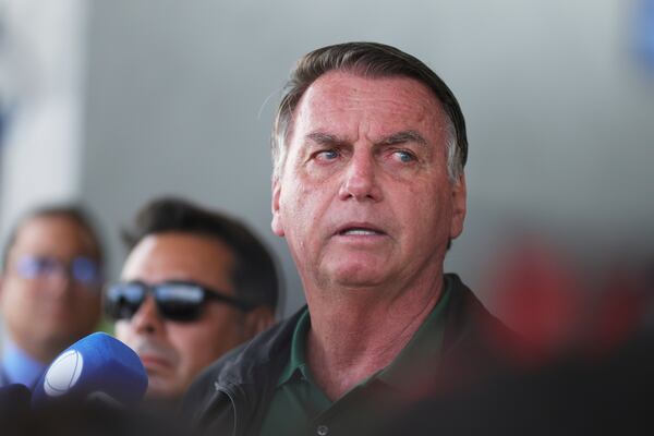 Brazil's former President Jair Bolsonaro speaks to the press as he arrives at the Brasilia International Airport in Brasilia, Brazil, Tuesday, March 25, 2025. (AP Photo/Luis Nova)