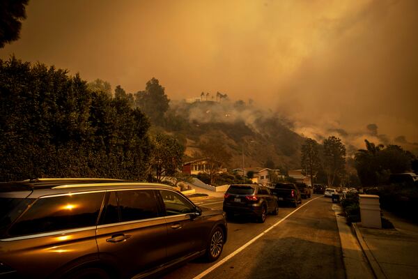 A line of vehicles crowds the road as residents flee from the Palisades Fire in the Pacific Palisades neighborhood of Los Angeles, Tuesday, Jan. 7, 2025. (AP Photo/Ethan Swope)