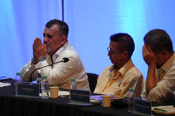 Gustavo Arbelaez, left, a former commander of the demobilized Revolutionary Armed Forces of Colombia (FARC), speaks during a hearing with the Special Jurisdiction for Peace, which encourages offenders to confess their crimes, in Cali, Colombia, Monday, Nov. 25, 2024. (AP Photo/Juan Bautista Diaz)