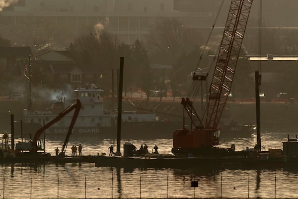 Rescue and salvage crews with cranes work near the wreckage of an American Airlines jet in the Potomac River from Ronald Reagan Washington National Airport, Monday, Feb. 2, 2025, in Arlington, Va. . (AP Photo/Jose Luis Magana)