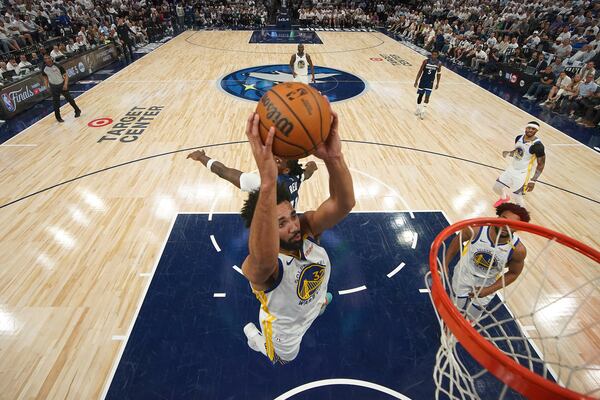 Golden State Warriors forward Trayce Jackson-Davis (32) goes up for a dunk as Minnesota Timberwolves center Naz Reid (11), back, defends during the second half of Game 2 of an NBA basketball second-round playoff series, Thursday, May 8, 2025, in Minneapolis. (AP Photo/Abbie Parr)