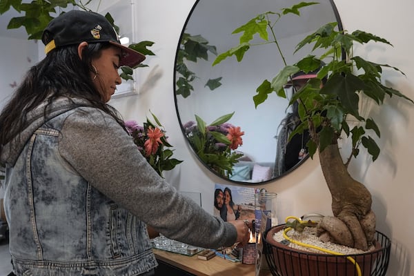 Released hostage Ilana Gritzewsky lights a candle for her boyfriend, Matan Zangauker, in her apartment in Kiryat Gat, Israel, Sunday, Dec. 15, 2024. Zangauker is being held hostage by Hamas in the Gaza Strip. (AP Photo/Tsafrir Abayov)