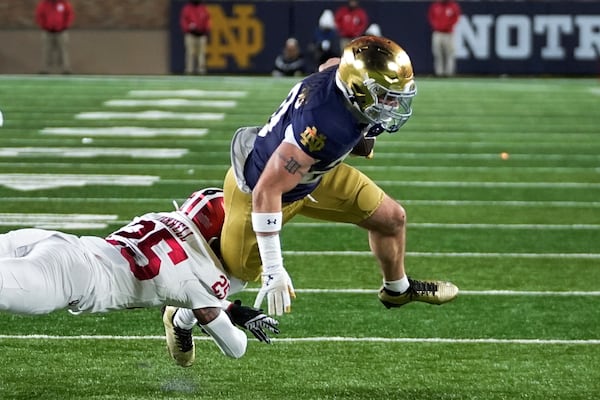 Notre Dame running back Dylan Devezin (25) is tackled by Indiana defensive back Amare Ferrell (25) during the second half in the first round of the NCAA College Football Playoff, Friday, Dec. 20, 2024, in South Bend, Ind. (AP Photo/Darron Cummings)