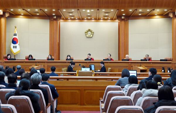 South Korea's Constitutional Court's judges, from left, Chung Kye-sun, Kim Bok-hyeong, Jung Jung-mi, Lee Mi-son, acting Chief Justice Moon Hyung-bae, Kim Hyung-du, Cheong Hyung-sik and Cho Han-chang sit for the first formal hearing of a trial on the validity of President Yoon Suk Yeol's impeachment by the National Assembly at the constitutional court of Korea in Seoul, South Korea, Tuesday, Jan. 14, 2025. (Kim Min-Hee/Pool Photo via AP)