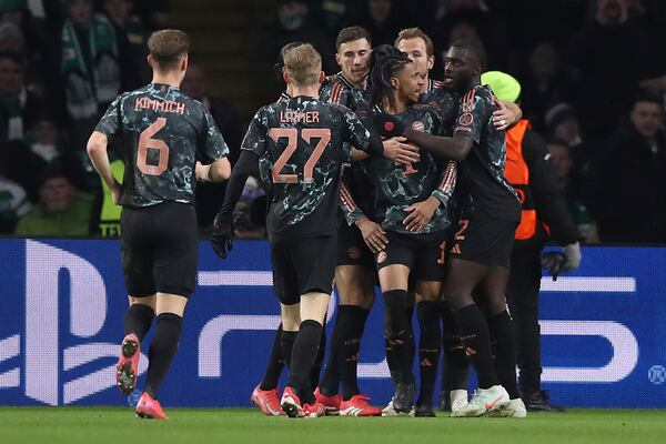 Bayern's Michael Olise, center, celebrates with team mates after scoring his side's opening goal during the Champions League play off first leg soccer match between Celtic Glasgow and Bayern Munich at the Celtic Park Stadium in Glasgow, Scotland, Wednesday, Feb. 12, 2025. (AP Photo/Scott Heppell)