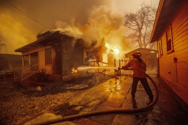 A firefighter battles the Eaton Fire Wednesday, Jan. 8, 2025 in Altadena, Calif. (AP Photo/Ethan Swope)