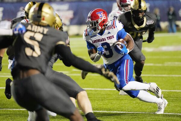 Louisiana Tech running back Marquis Crosby (3) runs upfield while pursued by Army players during the first half of the Independence Bowl NCAA college football game, Saturday Dec. 28, 2024, in Shreveport, La. (AP Photo/Rogelio V. Solis)