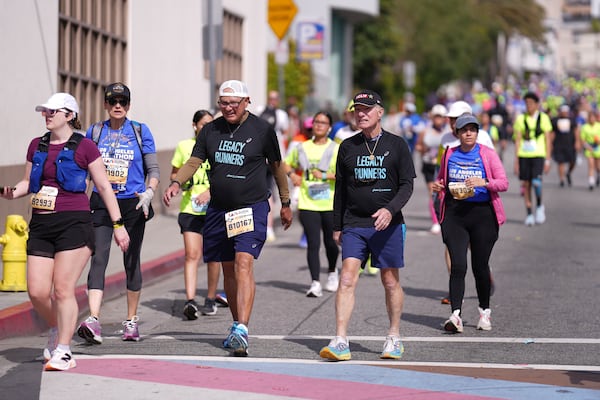 Cliff Housego, center right, and Lou Briones, center left, participate in the LA Marathon before the race Sunday, March 16, 2025, in Los Angeles. (AP Photo/Eric Thayer)