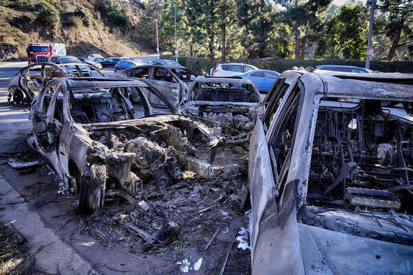 Destroyed and melted cars sit left along Sunset Blvd. after the wildfire that spread through the Pacific Palisades neighborhood of Los Angeles, Wednesday, Jan. 15, 2025. (AP Photo/Richard Vogel)