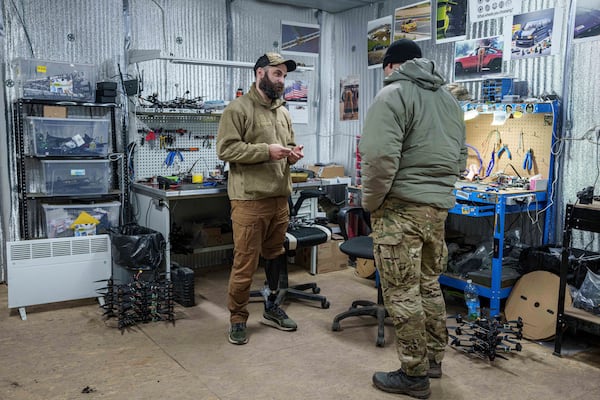 Pavlo Romanovskyi, chief of a Ukrainian drone laboratory who lost a leg in battle, talks to a fellow soldier in Ukraine's Kharkiv region on Feb. 12, 2025. (AP Photo/Evgeniy Maloletka)