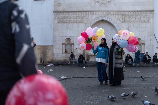 People pose for photos with balloons near Al-Hamidiyeh Souq on New Years Eve, in Damascus, Syria, Tuesday, Dec. 31, 2024 (AP Photo/Mosa'ab Elshamy)