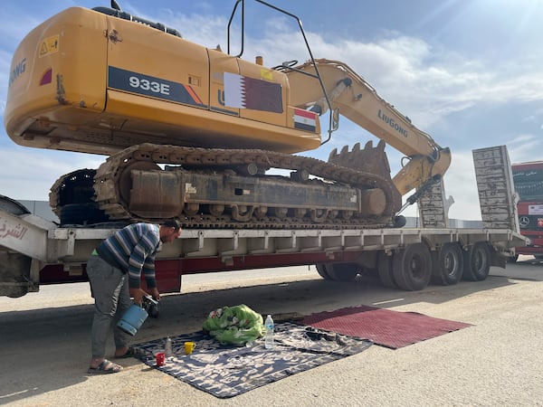 A truck driver waits with others carrying mobile homes on the Egyptian side of the Rafah crossing in preparation for entering Gaza, at the Rafah border crossing, Egypt, Tuesday, Feb. 18, 2025. (AP Photo/Mayar Mokhtar)