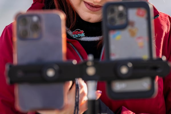 Wearing a button in support of TikTok, Tiffany Cianci, who says she is a "long-form educational content creator," livestreams to TikTok outside the Supreme Court, Friday, Jan. 10, 2025, in Washington. (AP Photo/Jacquelyn Martin)