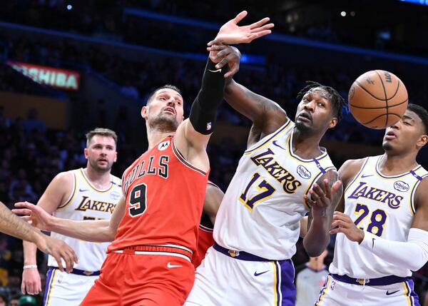 Chicago Bulls center Nikola Vucevic (9) and Los Angeles Lakers forward Dorian Finney-Smith (17) battle for a rebound in the first half of an NBA basketball game Saturday, March 22, 2025, in Los Angeles. (AP Photo/Wally Skalij)