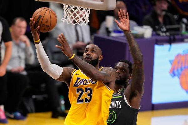Los Angeles Lakers forward LeBron James, left, shoots as Minnesota Timberwolves guard Donte DiVincenzo defends in the closing seconds in Game 5 of an NBA basketball first-round playoff series Wednesday, April 30, 2025, in Los Angeles. (AP Photo/Mark J. Terrill)
