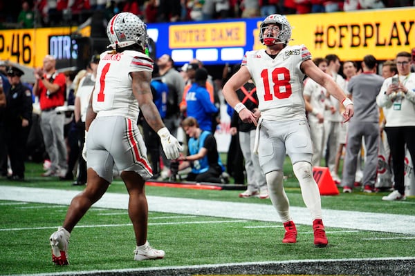 Ohio State quarterback Will Howard celebrates after a touchdown by running back Quinshon Judkins during second half of the College Football Playoff national championship game against Notre Dame Monday, Jan. 20, 2025, in Atlanta. (AP Photo/Jacob Kupferman)