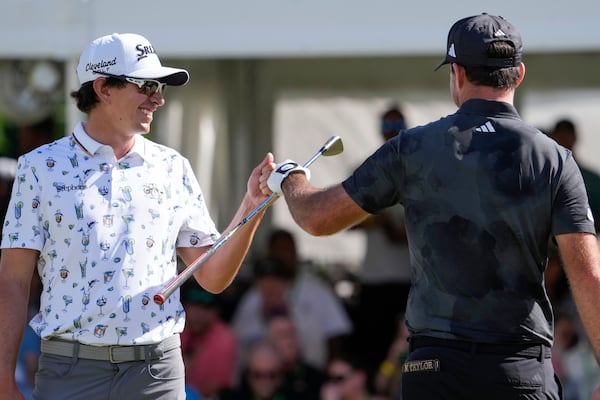 Nico Echavarria, left, of Columbia, greets Nick Taylor, of Canada, after Taylor made a shot on the 18th green during the final round of the Sony Open golf event, Sunday, Jan. 12, 2025, at Waialae Country Club in Honolulu. (AP Photo/Matt York)