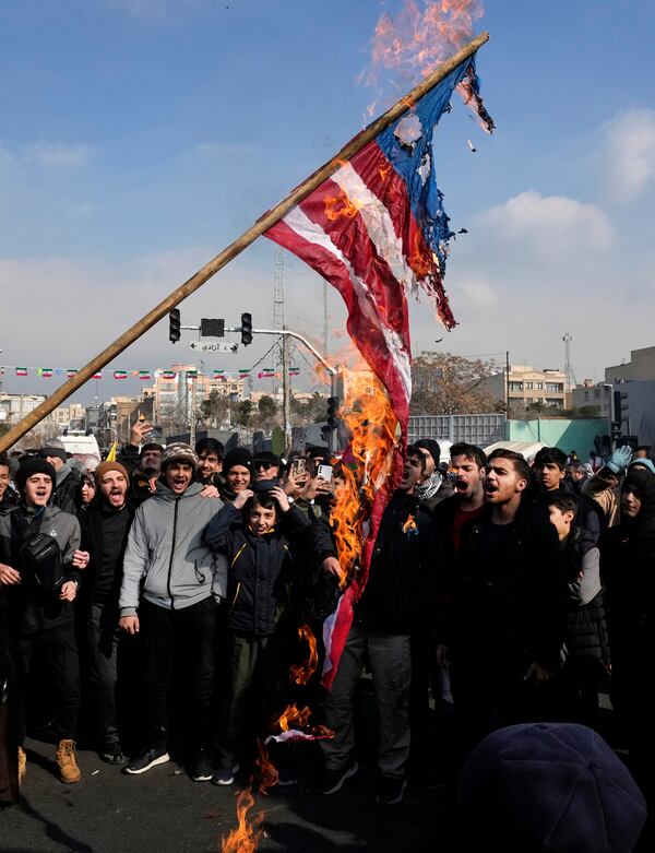 Iranian demonstrators burn a representation of the U.S. flag during a rally commemorating anniversary of 1979 Islamic Revolution that toppled the late pro-U.S. Shah Mohammad Reza Pahlavi and brought Islamic clerics to power, in Tehran, Iran, Monday, Feb. 10, 2025. (AP Photo/Vahid Salemi)