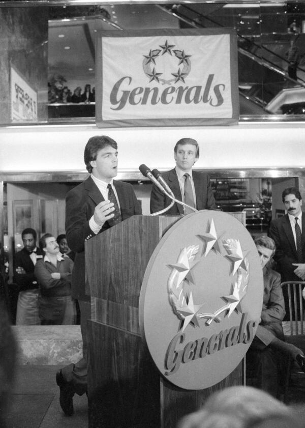 FILE - Doug Flutie, the New Jersey Generals newly-signed quarterback, talks to reporters during a news conference in New York, Feb. 6, 1985, after he was signed by the team's owner, Donald Trump, right, for four years at approximately $7 million. (AP Photo/Marty Lederhandler, File)