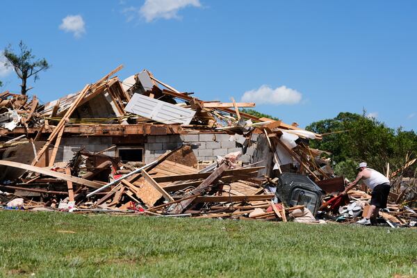 A person looks through the damage at a destroyed home, Saturday, May 17, 2025, in London, Ky (AP Photo/Carolyn Kaster)
