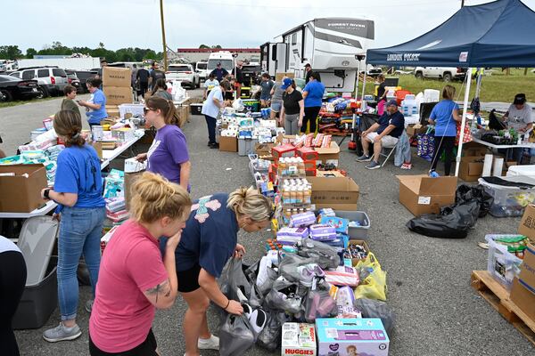 Volunteers sort food and clothing for distribution at the command center at the London-Corbin Airport in London, Ky., Monday, May 19, 2025. (AP Photo/Timothy D. Easley)