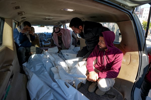 Mourners transport the bodies of their relatives killed in the Israeli bombardment of the Gaza Strip, during their funeral in Deir al-Balah, Wednesday, Jan. 8, 2025. (AP Photo/Abdel Kareem Hana)