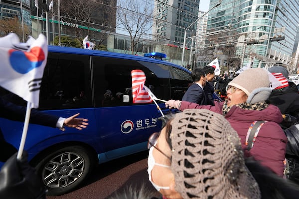 Supporters for impeached South Korean President Yoon Suk Yeol greet as his motorcade passes by near the Seoul Western District Court in Seoul, South Korea, Saturday, Jan. 18, 2025. (AP Photo/Lee Jin-man)