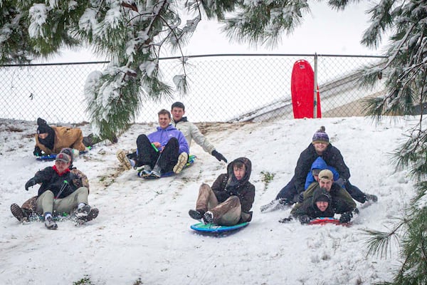 Sledders ride down a hill as snow falls, Friday, Jan. 10, 2025, in Florence, Ala. (Dan Busey/The TimesDaily via AP)