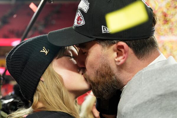 Kansas City Chiefs tight end Travis Kelce kisses Taylor Swift as they celebrate the Chiefs victory over the Buffalo Bills in the AFC Championship NFL football game, Sunday, Jan. 26, 2025, in Kansas City, Mo. (AP Photo/Charlie Riedel)