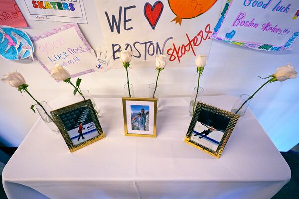 Six white roses and photographs of victims are displayed at The Skating Club of Boston, Thursday, Jan. 30, 2025, in Norwood, Mass. (AP Photo/Charles Krupa)