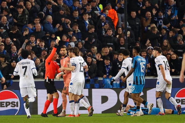 The referee shows the yellow card to the Atalanta's Isak Hien during the Champions League playoff first leg soccer match between Club Brugge and Atalanta at the Jan Breydel Stadium in Bruges, Belgium, Wednesday, Feb. 12, 2025. (AP Photo/Geert Vanden Wijngaert)