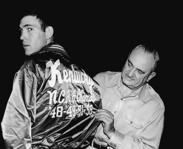 FILE - University of Kentucky coach Adolph Rupp looks over the jacket worn by Johnny Cox, December 1, 1958 at the Lexington, Ky. campus. (AP Photo, file)